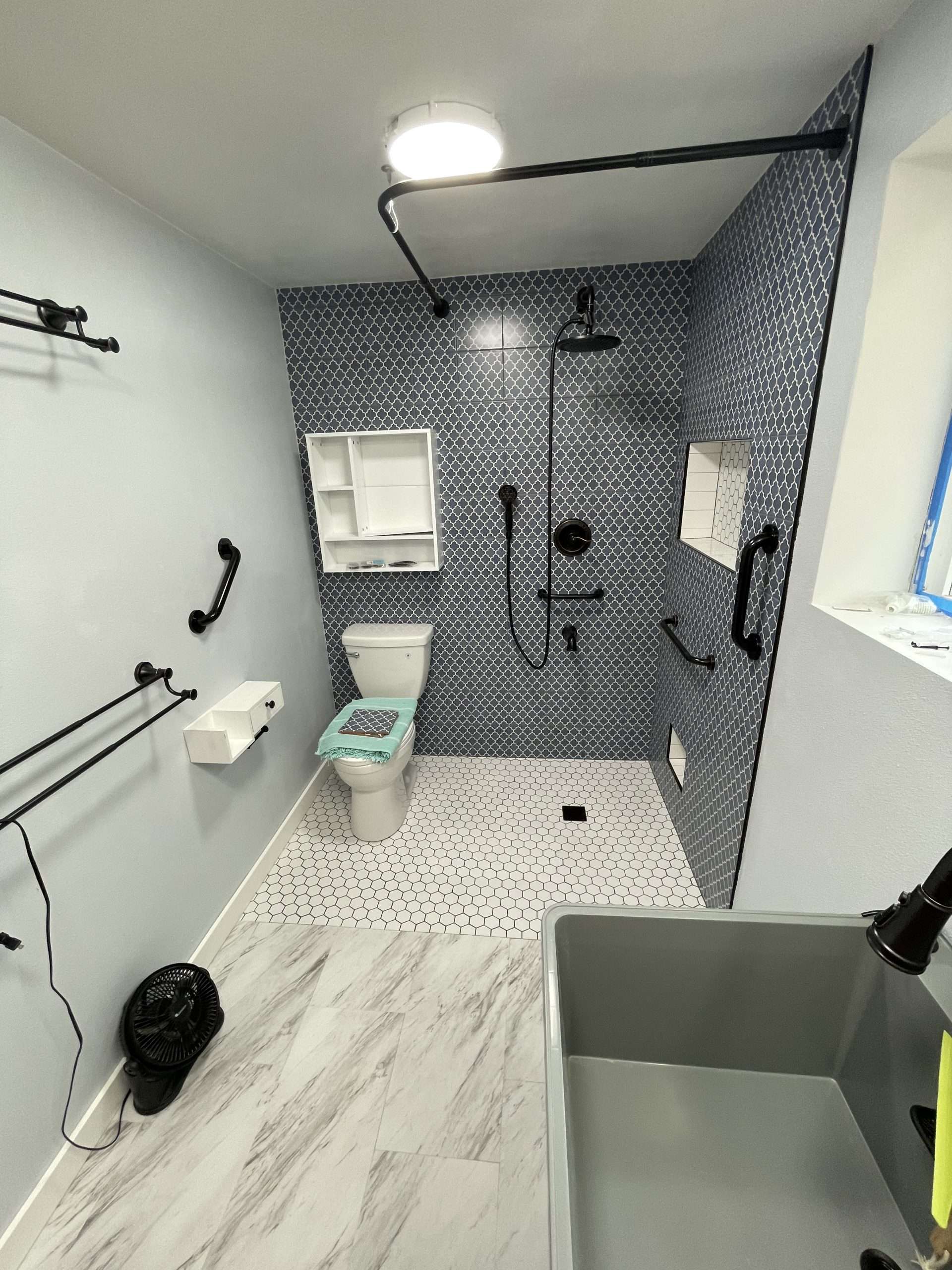 Modern bathroom with blue tiles and accessibility features